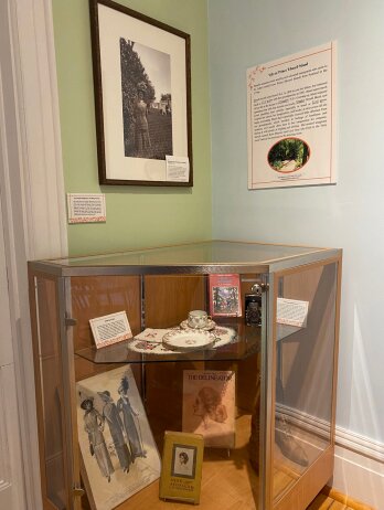 Corner display with exhibit panel and hanging art.